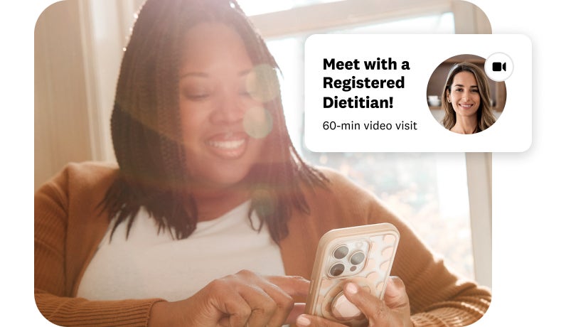 woman smiling at her phone featuring a registered dietitian app screen
