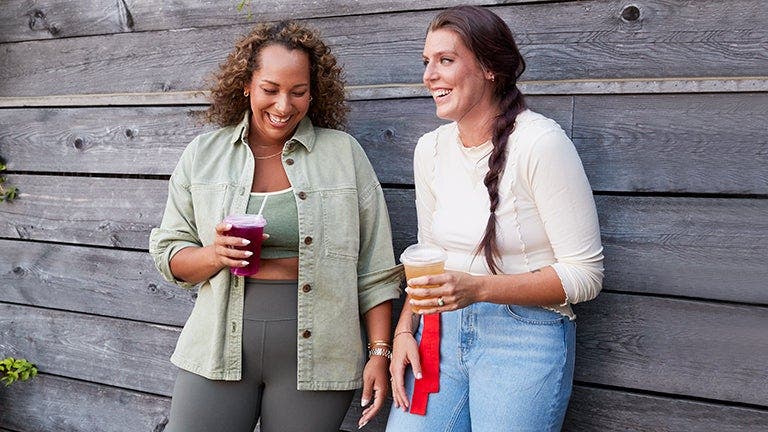 Two friends talking and drinking refreshments. 