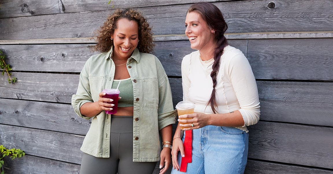 Two friends talking and drinking refreshments.