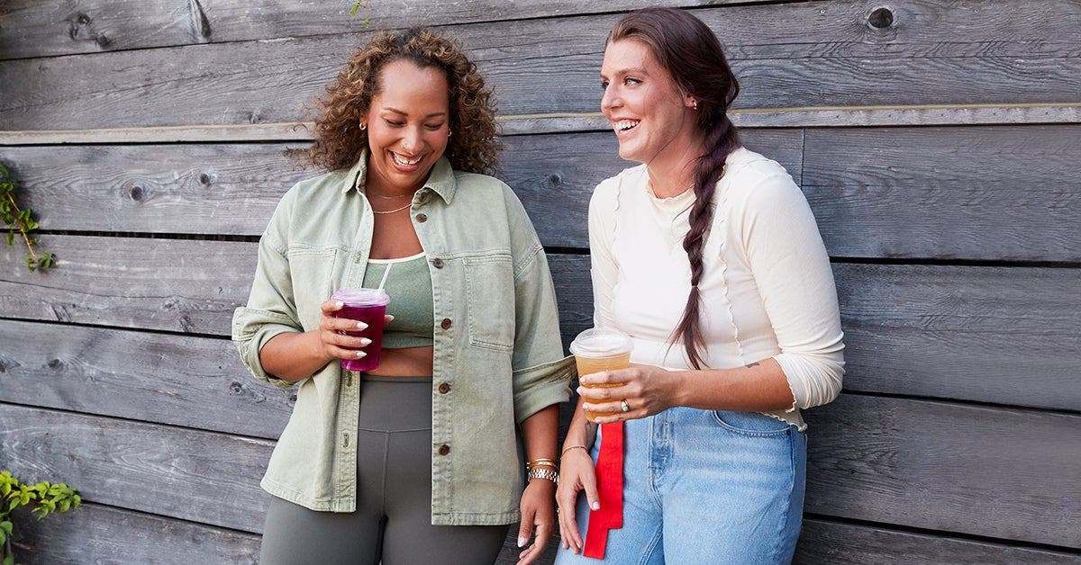 Two friends talking and drinking refreshments.