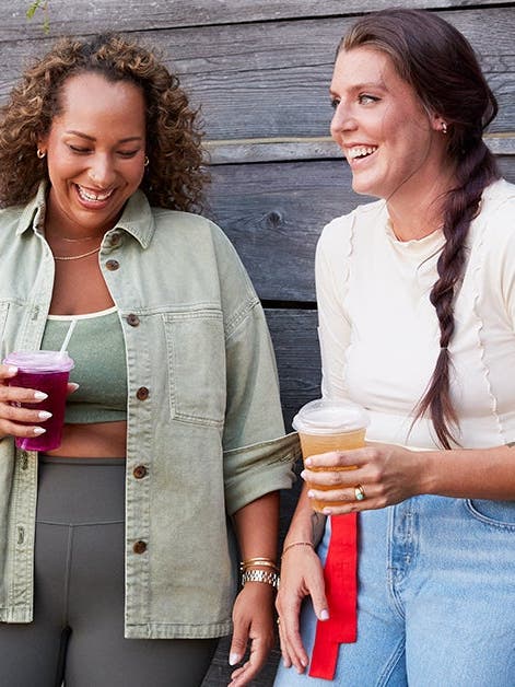 Two friends talking and drinking refreshments.