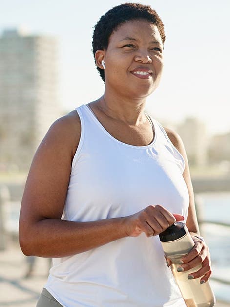 woman jogging at the waterfront with water bottle