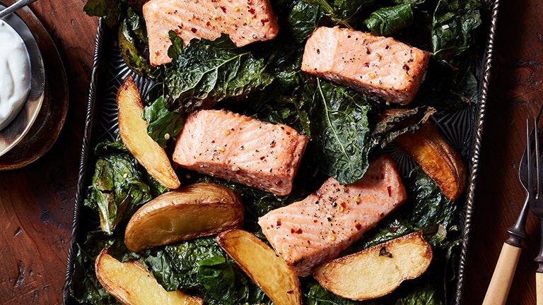 roasted salmon in a sheet pan with crispy kale and golden potatoes