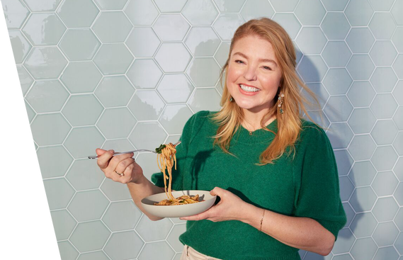 Woman eating a bowl of pasta.
