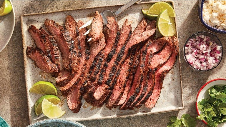 A plate of steak with lime slices and other ingredients, creating a delicious and vibrant dish.