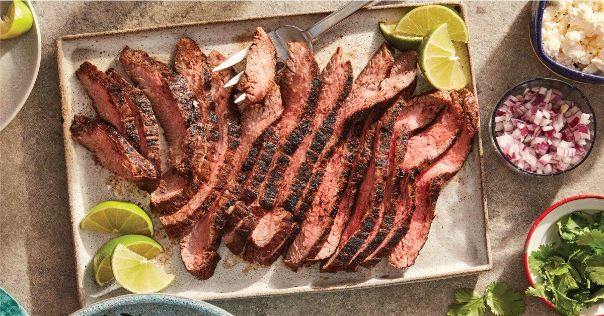 A plate of steak with lime slices and other ingredients, creating a delicious and vibrant dish.