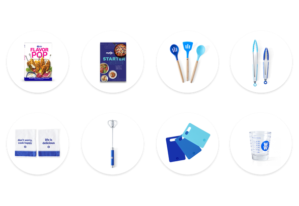 Image of kitchen essentials kit featuring silicone utensils, a cookbook, cutting boards, and many more items