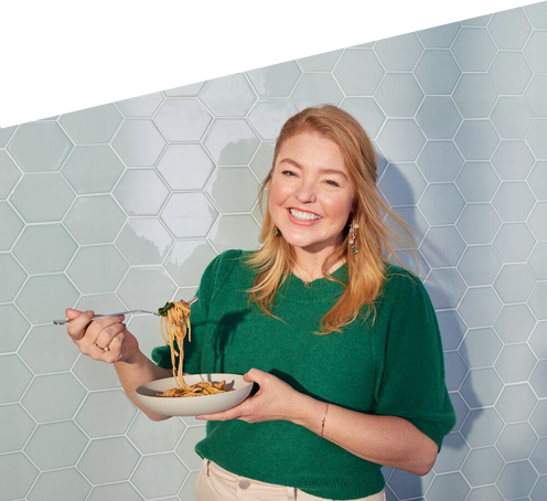 Woman eating a bowl of pasta.
