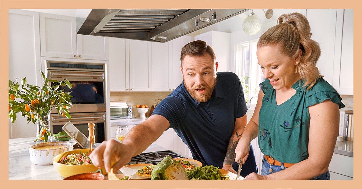 WW Members, Emily and Josh, preparing a meal in the kitchen