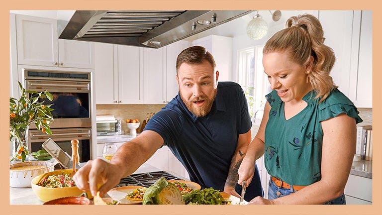 WW Members, Emily and Josh, preparing a meal in the kitchen