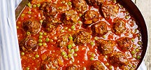Boulettes de viande avec une sauce de tomates et des pois