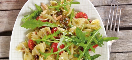 Italienischer Farfallesalat mit Rucola und Pinienkernen