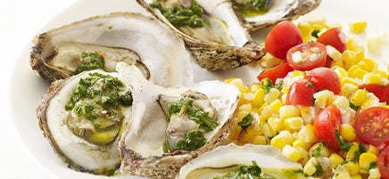 Huîtres grillées accompagnées de chimichurri et d’une salade de tomates et maïs