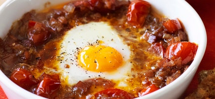Baked egg with spicy tomato, bacon and onion
