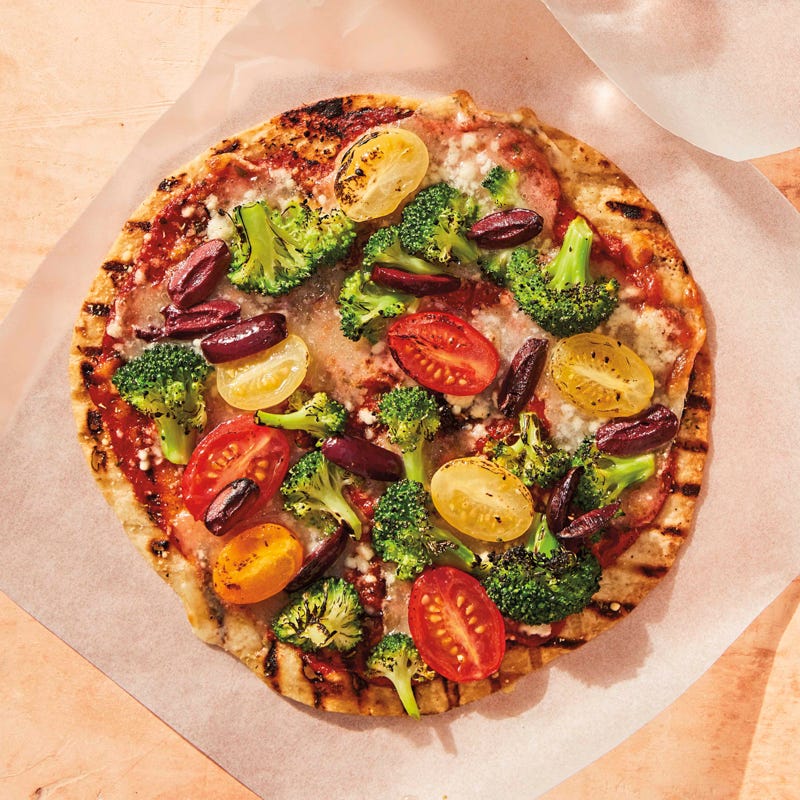 Grilled broccoli, cherry tomato, and olive pizzas