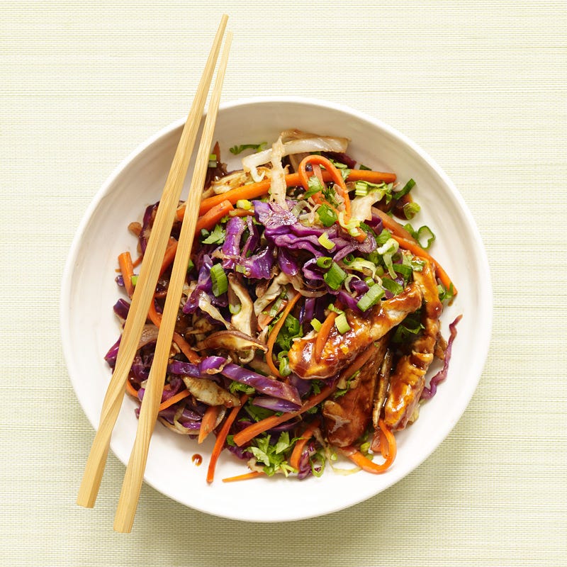 a bowl of stir-fried strips of pork and sliced cabbage, carrot and mushrooms in a hoisin-based sauce served with chopsticks