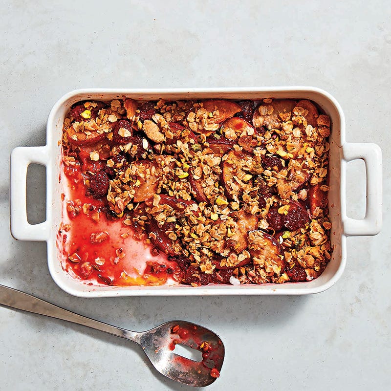 Large rectangular baking dish filled with a plum & blackberry crisp with pistachio crumble topping