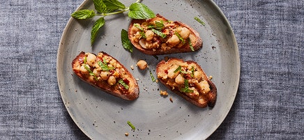 Crostini with smashed chickpeas, sun-dried tomatoes and mint