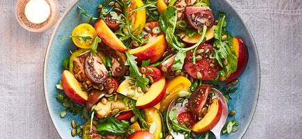 Salade de tomates et de nectarines avec oignons verts et graines de citrouille