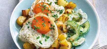 Œufs au plat, pommes de terre rissolées et salade de concombre