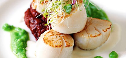 Saint-Jacques poêlées avec purée de pois, tomates grillées et sauce prosecco