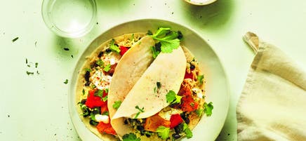 Burrito aux poivrons rouges avec haricots noirs, riz et sauce yaourt citron vert