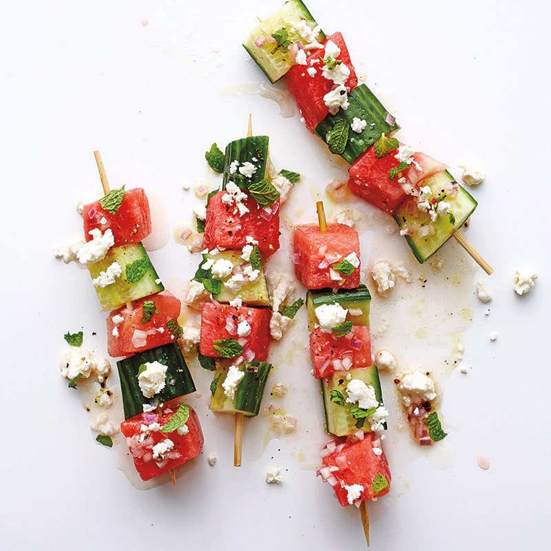 chunks of watermelon and cucumber threaded on short wooden skewers, sprinkled with feta, mint and a lime dressing