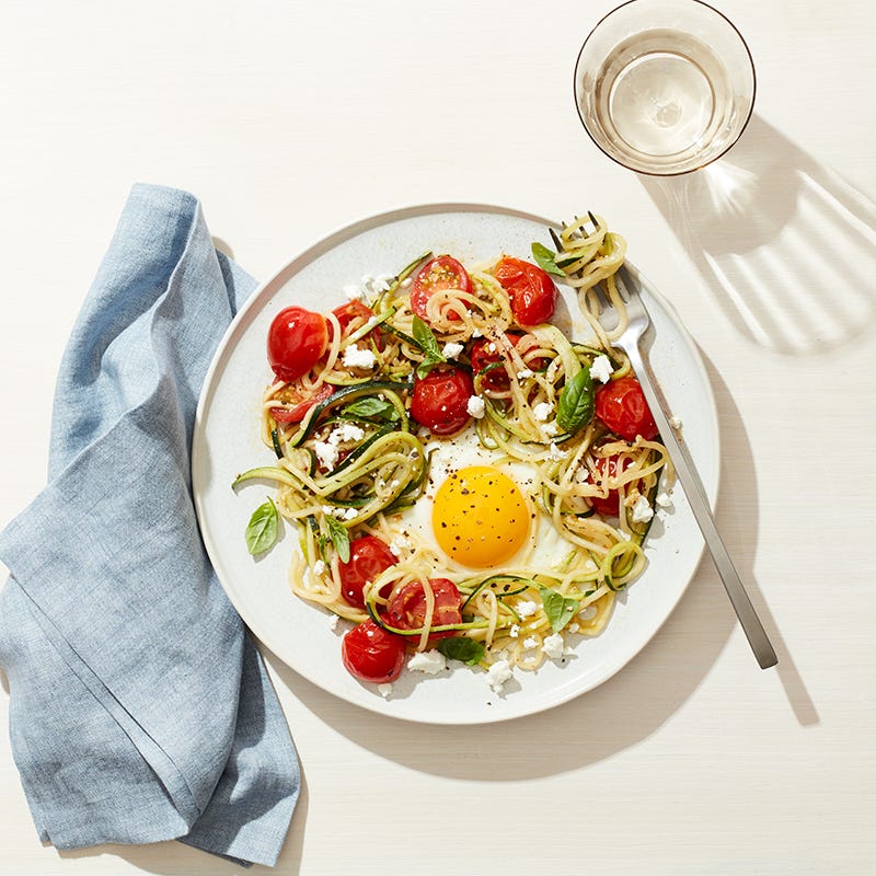 Egg in a zucchini noodle nest with tomato, basil and feta