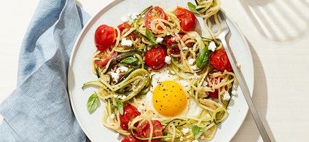 Egg in a zucchini noodle nest with tomato, basil and feta