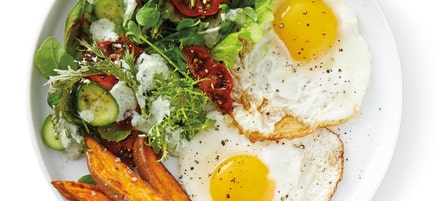 Fried eggs with roasted sweet potato wedges and mixed greens