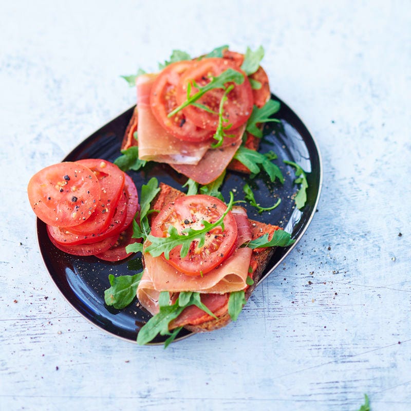 Roggenvollkornbrot mit Rohschinken, Rucola und Tomaten