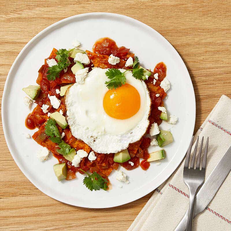 Chilaquiles with fried eggs, cheese, and avocado