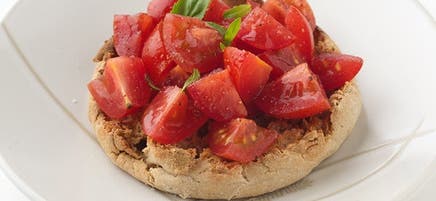 Muffin anglais garni de tomates et de basilic