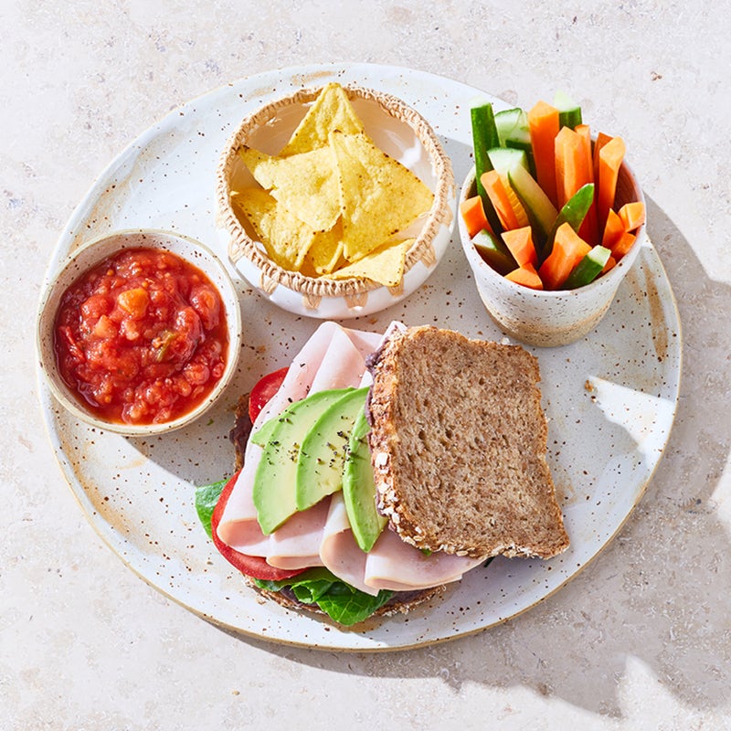 Puten-Avocado-Sandwich mit Tortillachips und Gemüsesticks